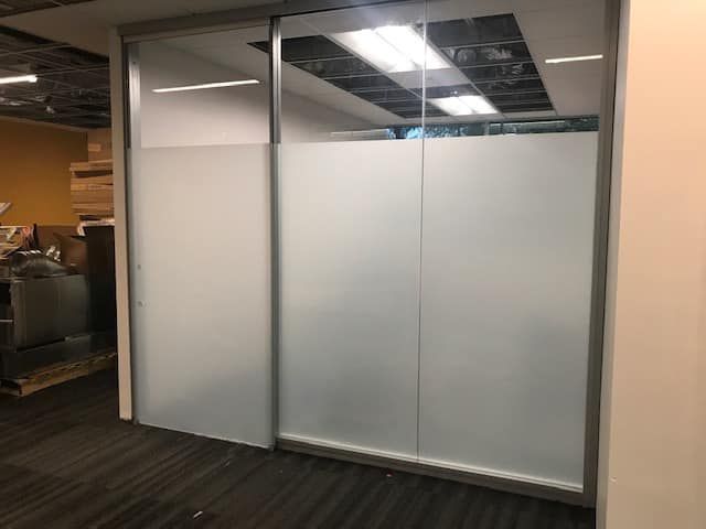 A room with a glass wall and a sliding glass door.