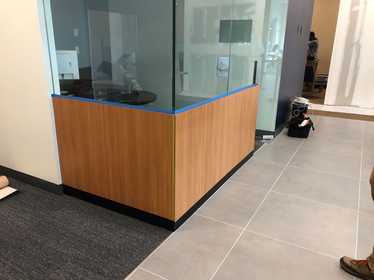 A person is standing next to a wooden wall in a room.