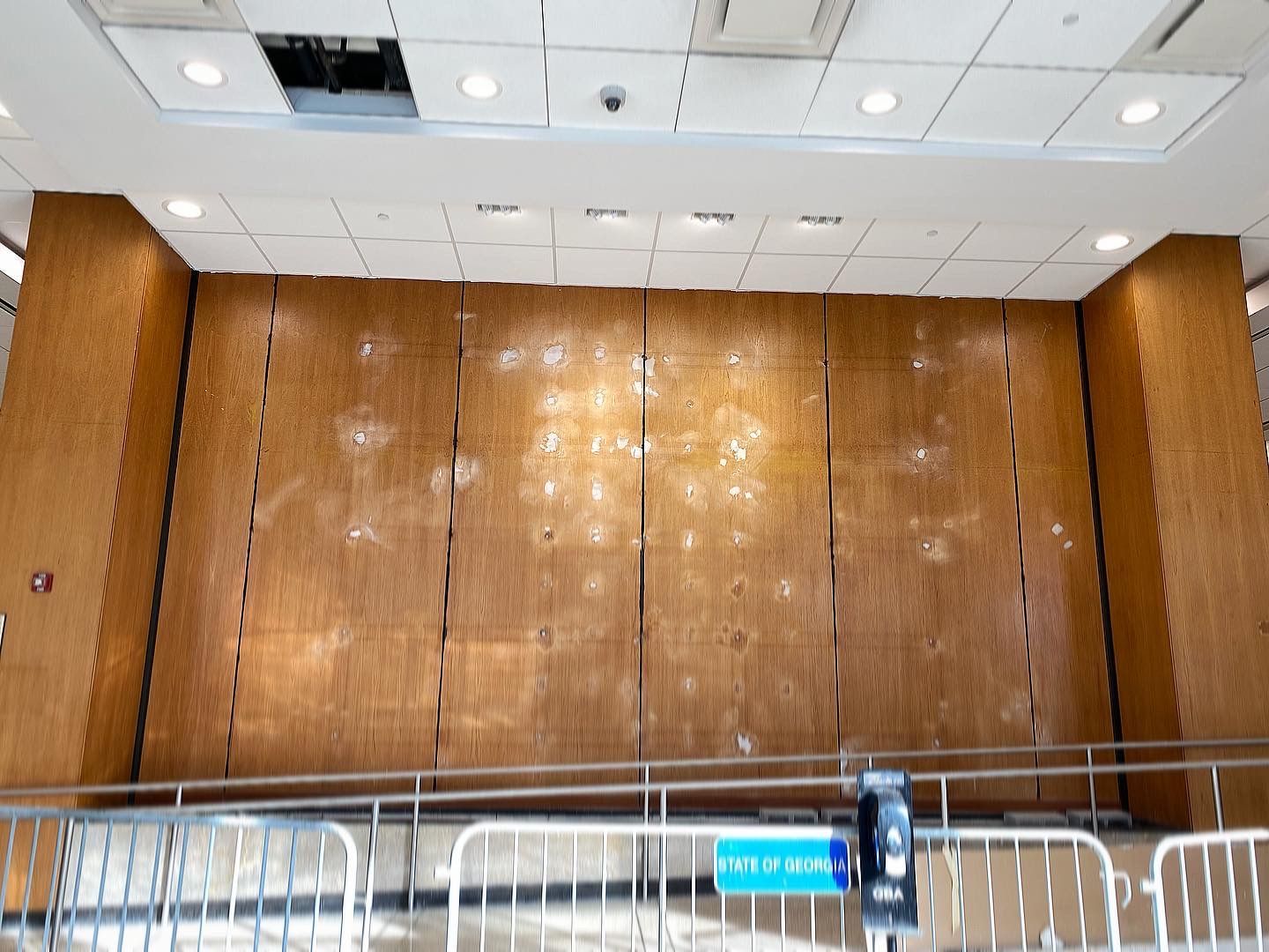 A large wooden wall with a blue sign that says 