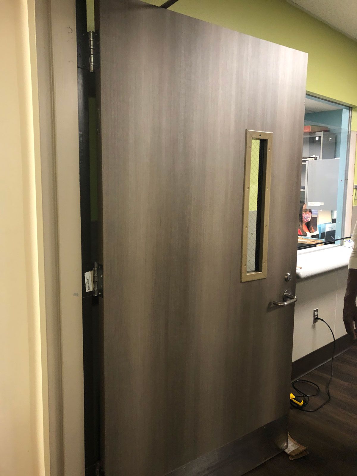 A wooden door with a small window in a room.