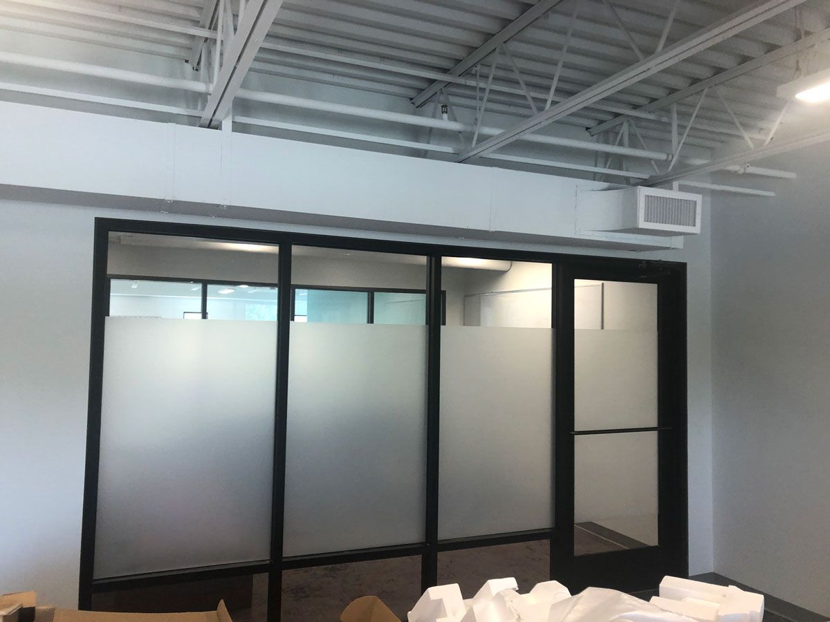 A room with sliding glass doors and frosted glass on the windows