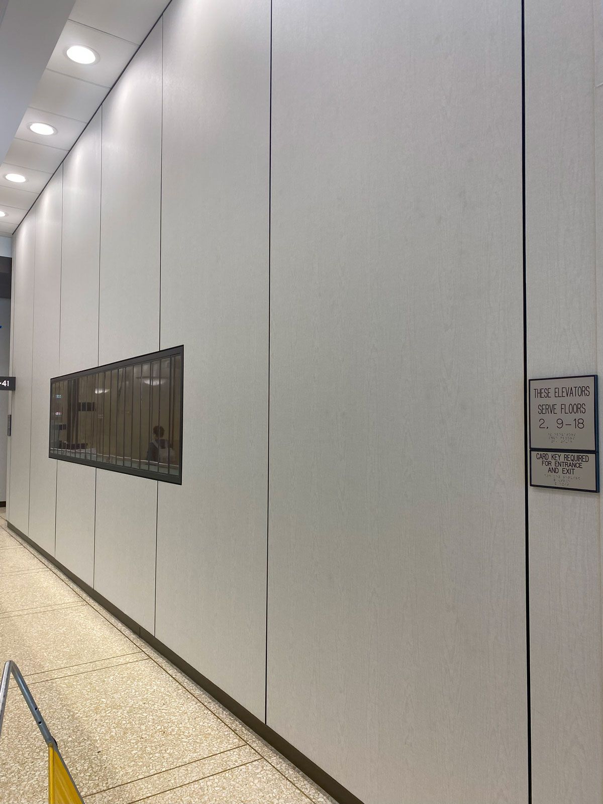 A long hallway with white walls and a yellow line on the floor.