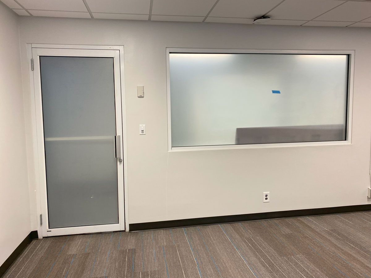 An empty room with a door and a window.