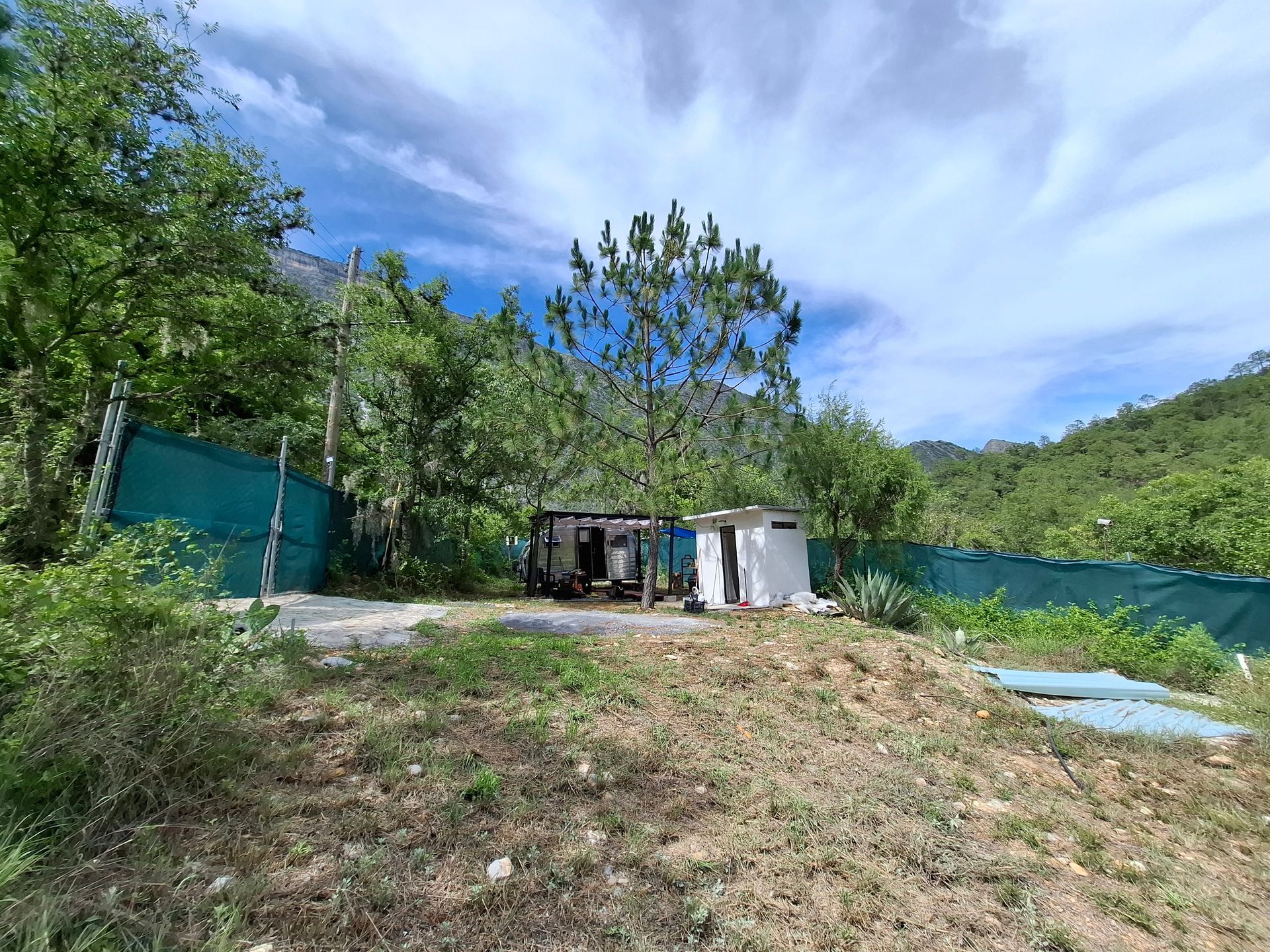 Una pequeña casa está situada en la cima de una colina en medio de un bosque.