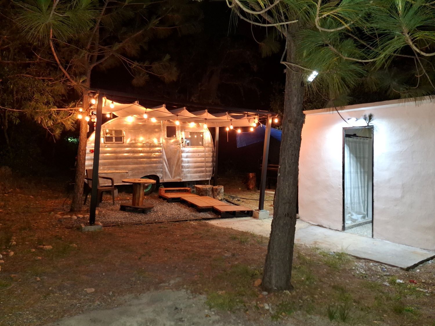 Un remolque está estacionado bajo un toldo por la noche.