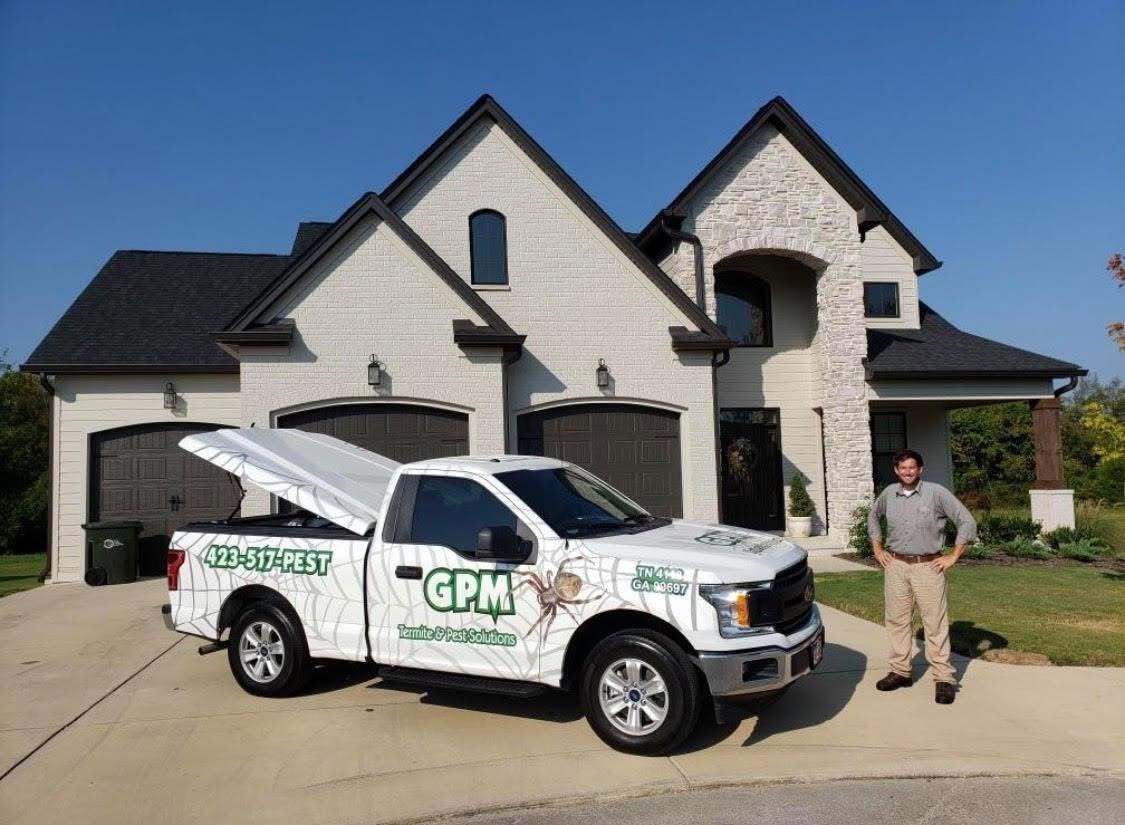 A gpm truck is parked in front of a house