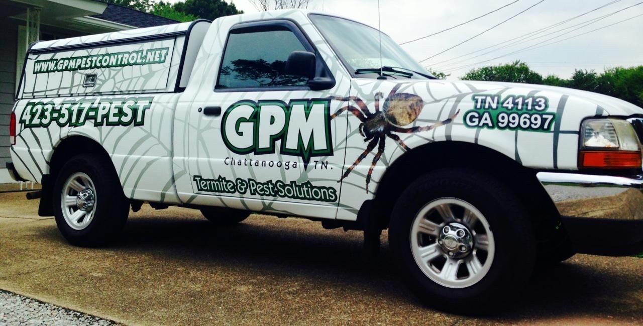 A white gpm truck is parked in front of a house