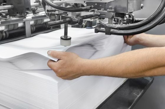 Man holding the paper during printing