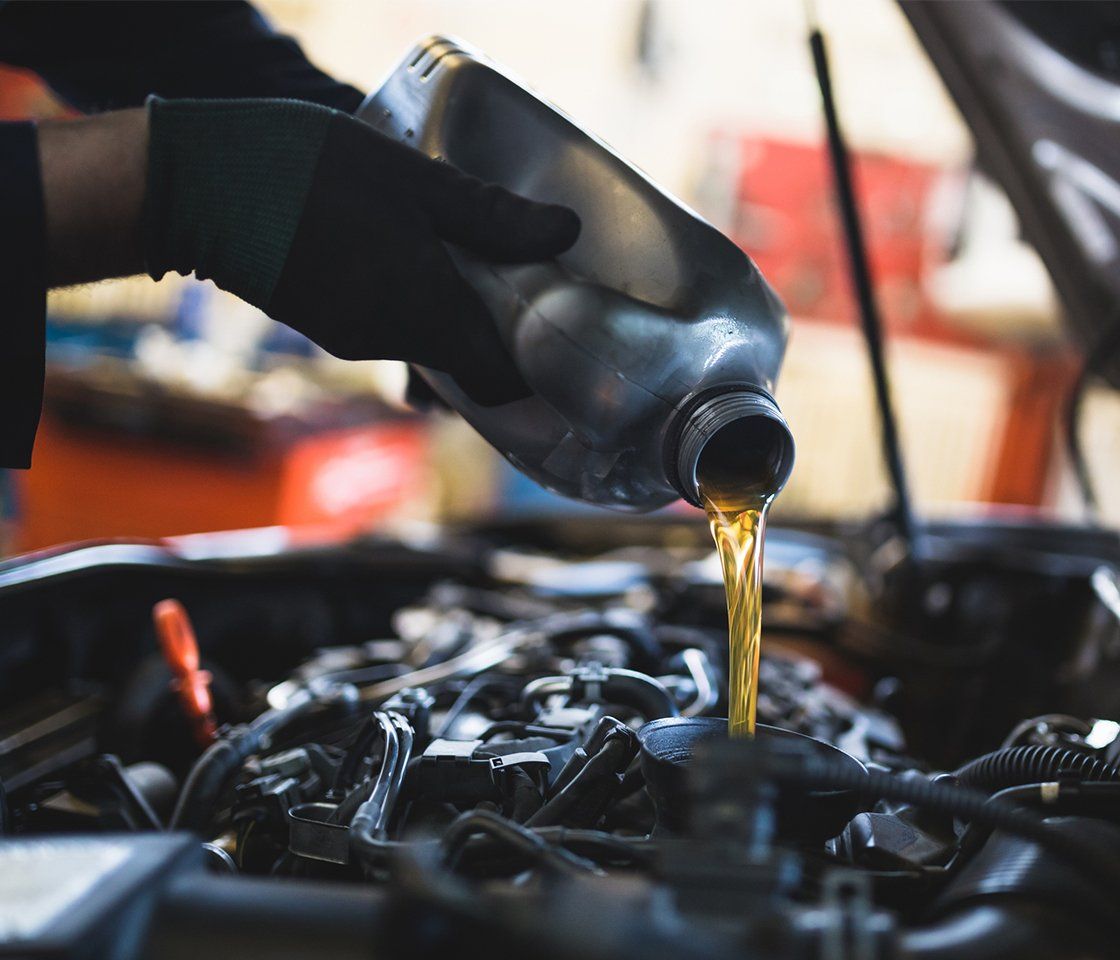 Person Filling Up New Oil — Ludlow, MA — Baldwin Auto Repair