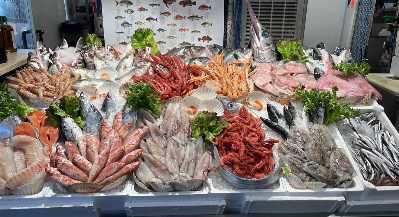 Frutti di mare freschi sul ghiaccio, tra cui pesci, piccoli polpi e gamberi rossi.