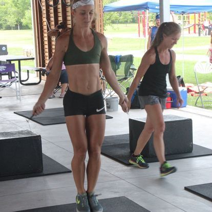 Fit female athlete jumping rope in a gym setting, demonstrating speed and agility.