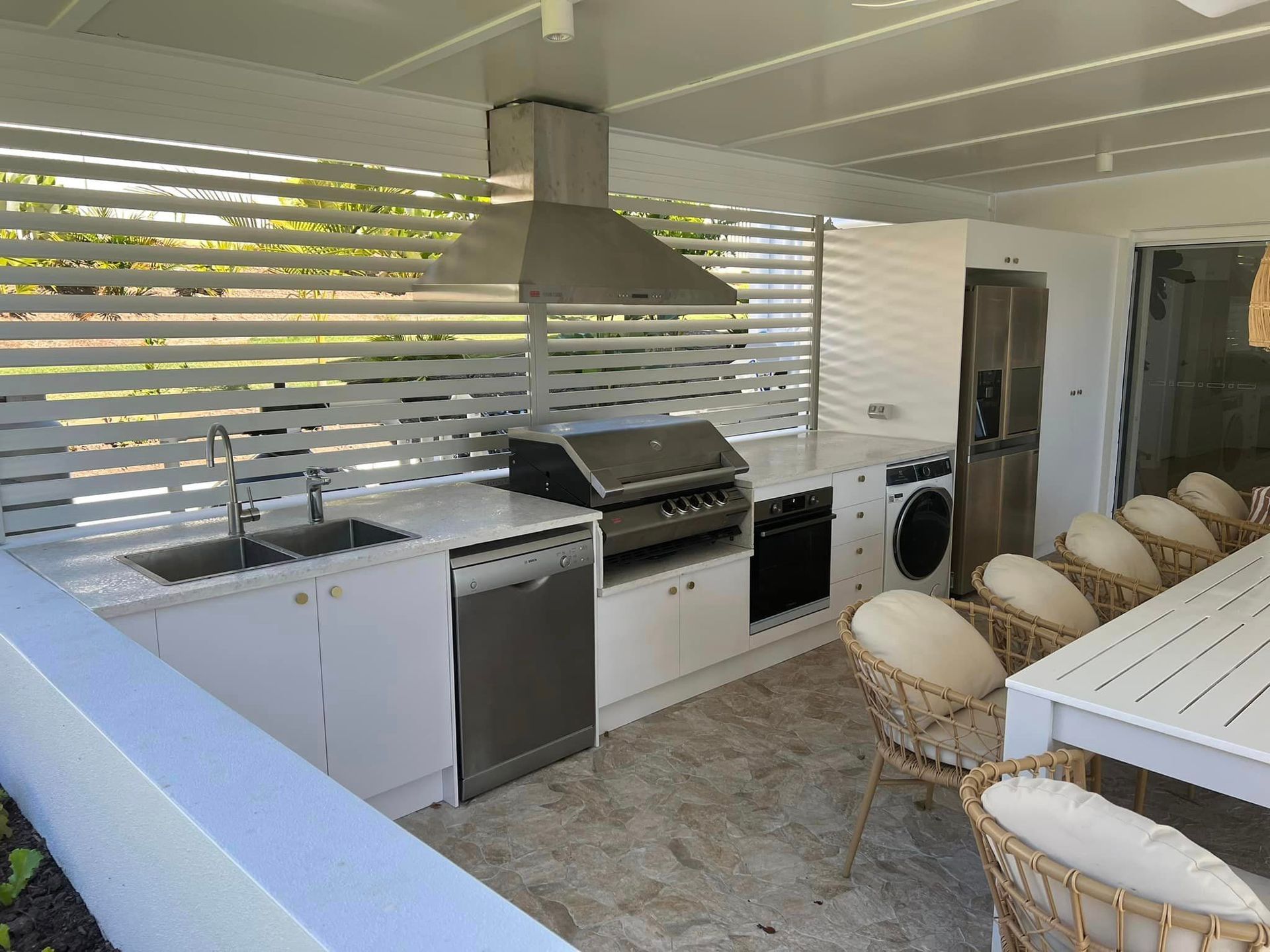 A kitchen with a table and chairs and a grill