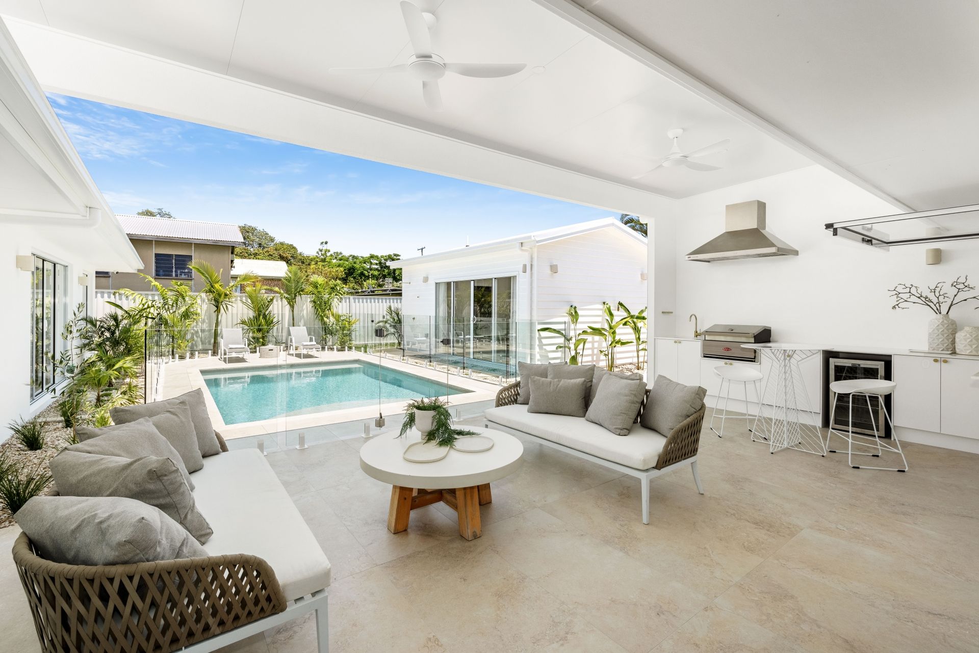 A living room with a couch , table , chairs and a swimming pool.