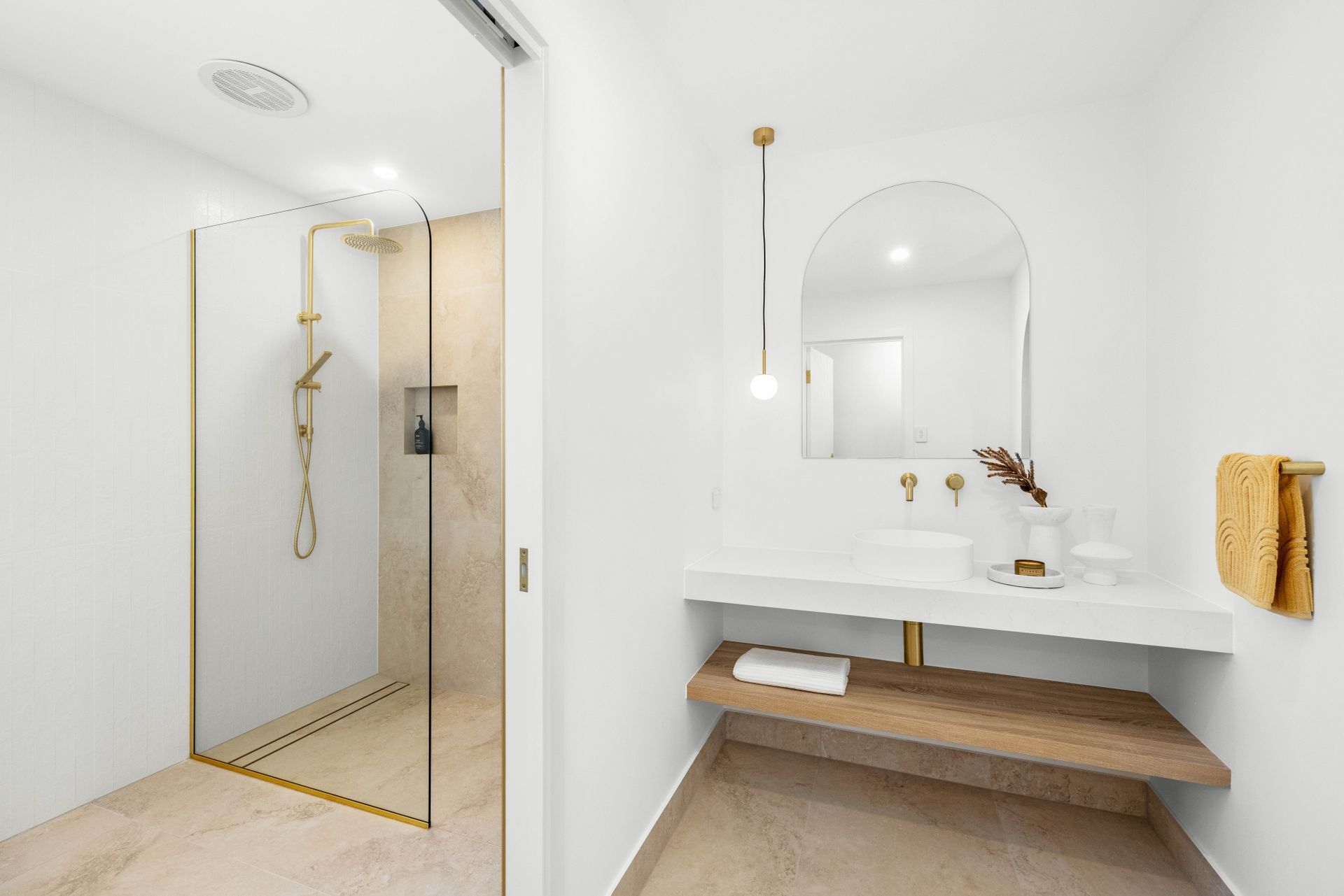 A bathroom with a sink , mirror and walk in shower.