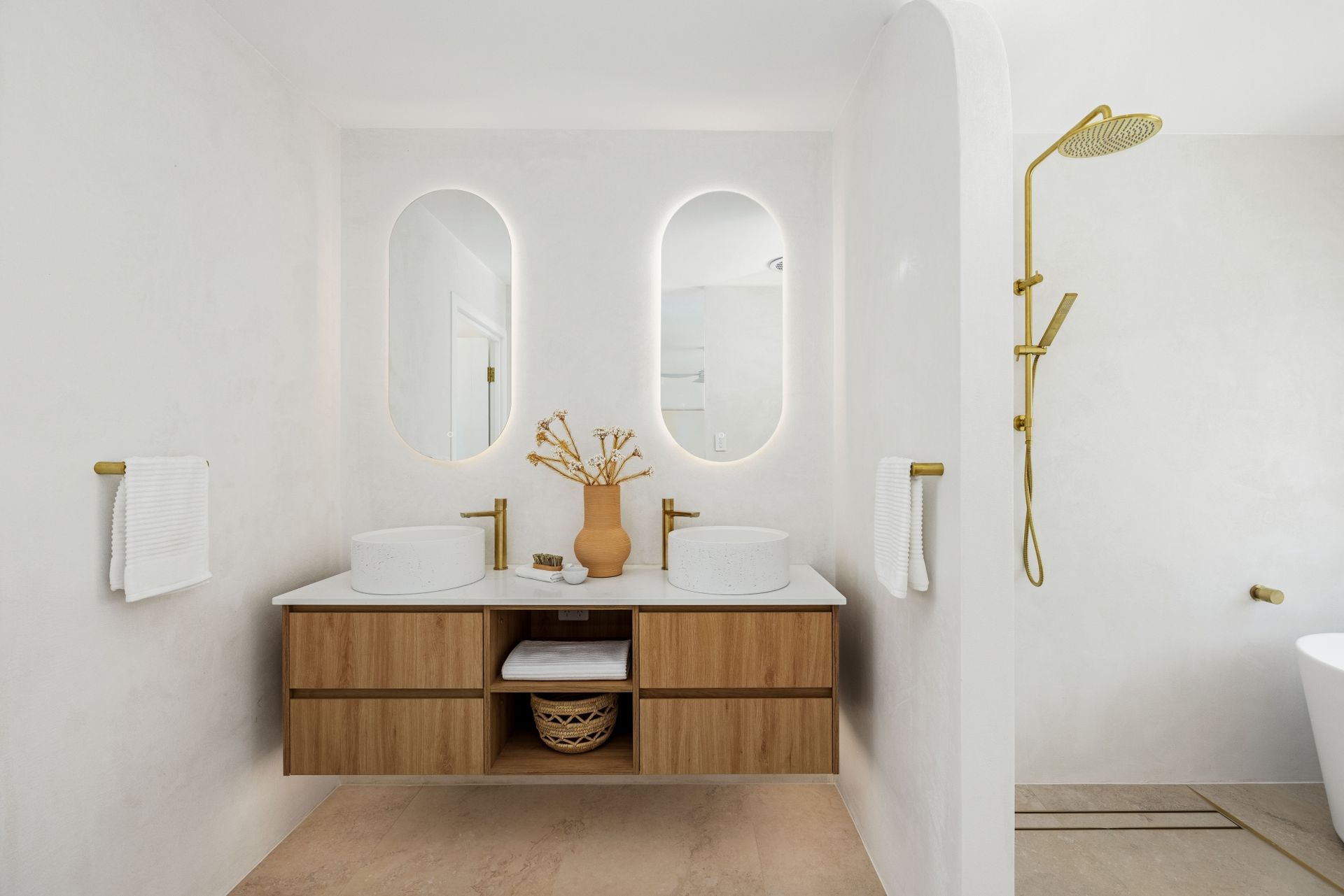 A bathroom with two sinks , two mirrors , a tub and a shower.