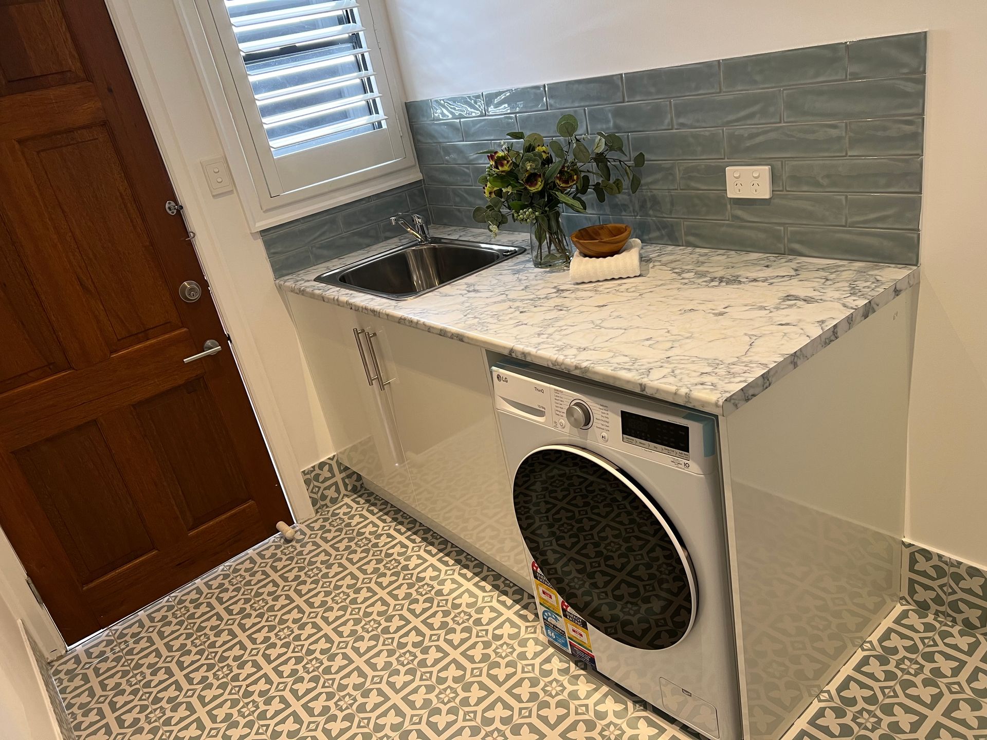 A laundry room with a washer and dryer and a sink.