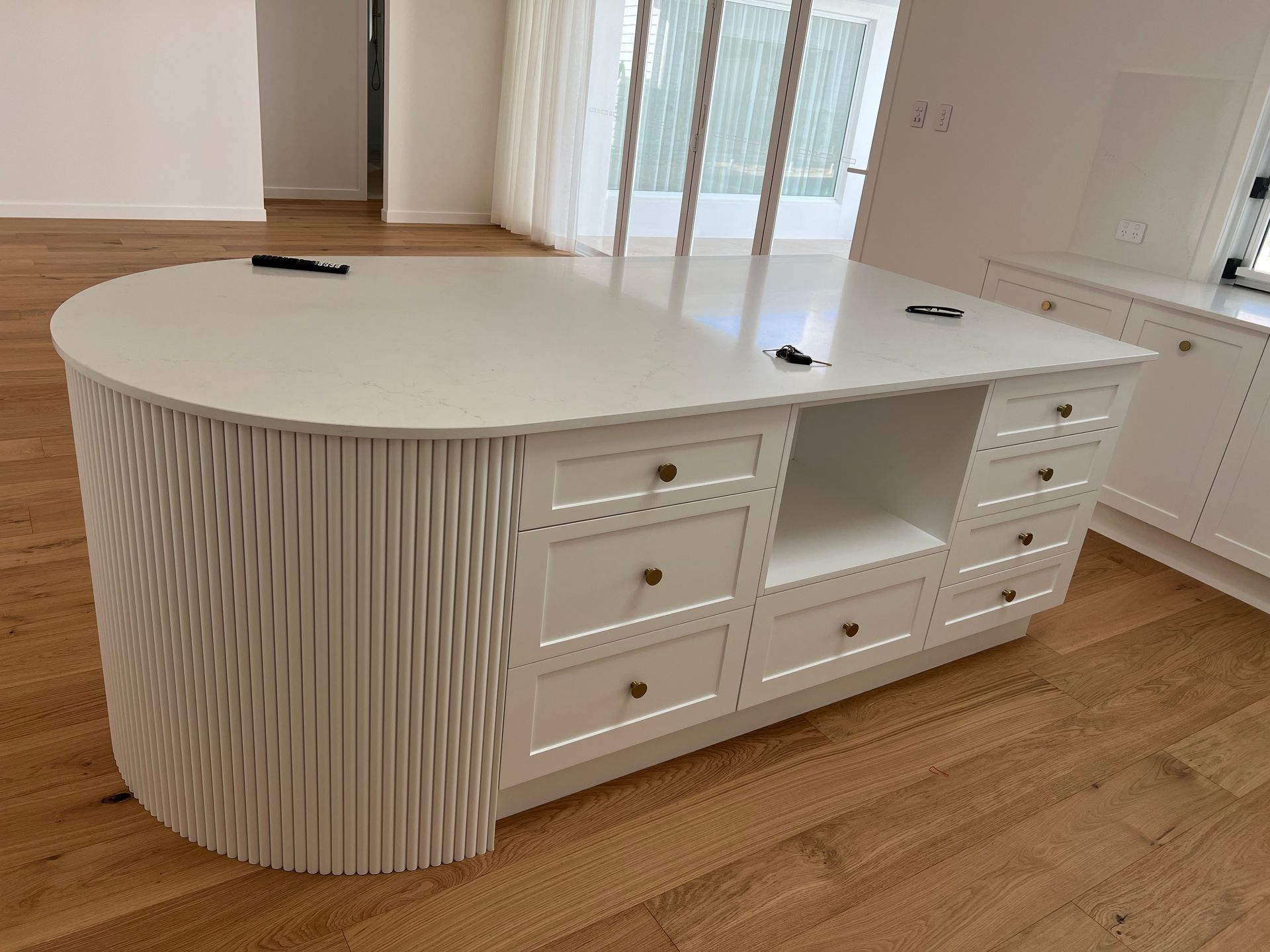 There is a large white island in the middle of the room.