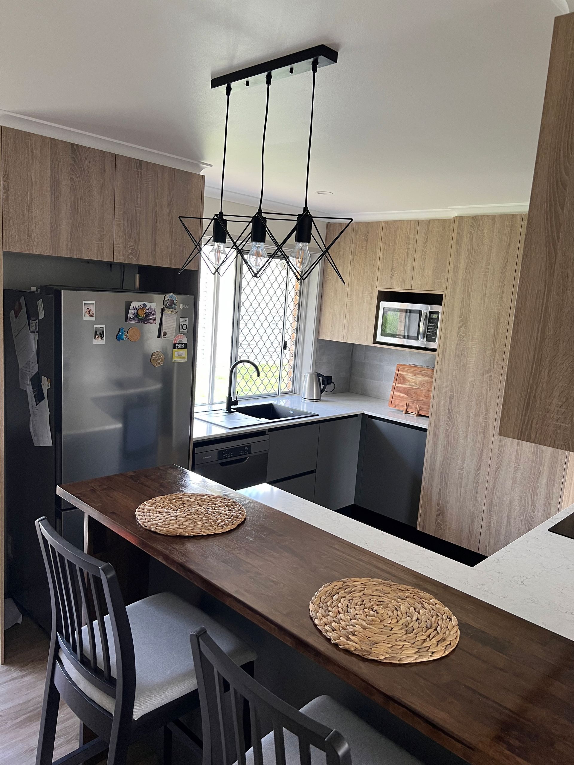 A kitchen with a table and chairs and a refrigerator.