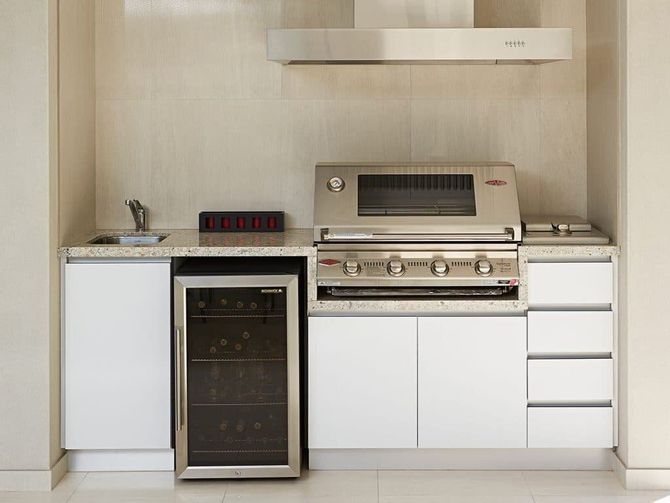 A kitchen with a grill and a wine cooler