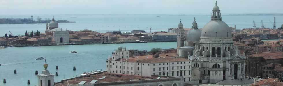 A panoramic view of Venice, Italy, featuring the domed Basilica di Santa Maria della Salute overlooking the water.
