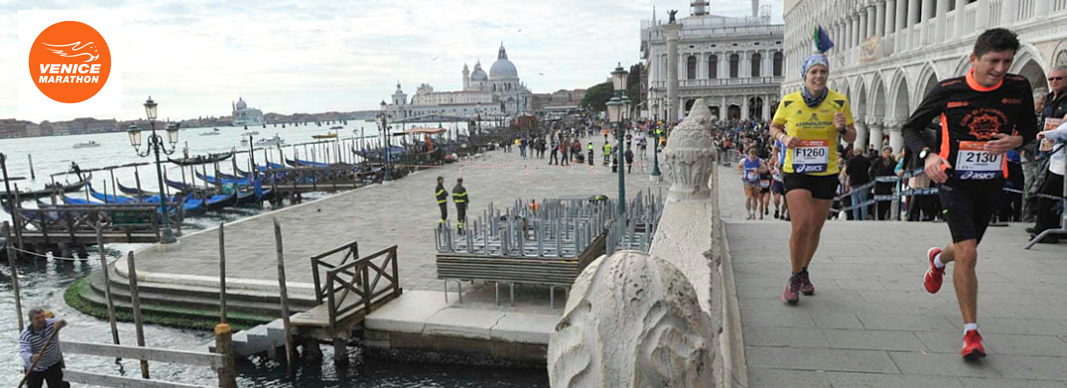 Runners jog along a stone promenade in Venice, with the canal, docked gondolas, and historic architecture in the background.