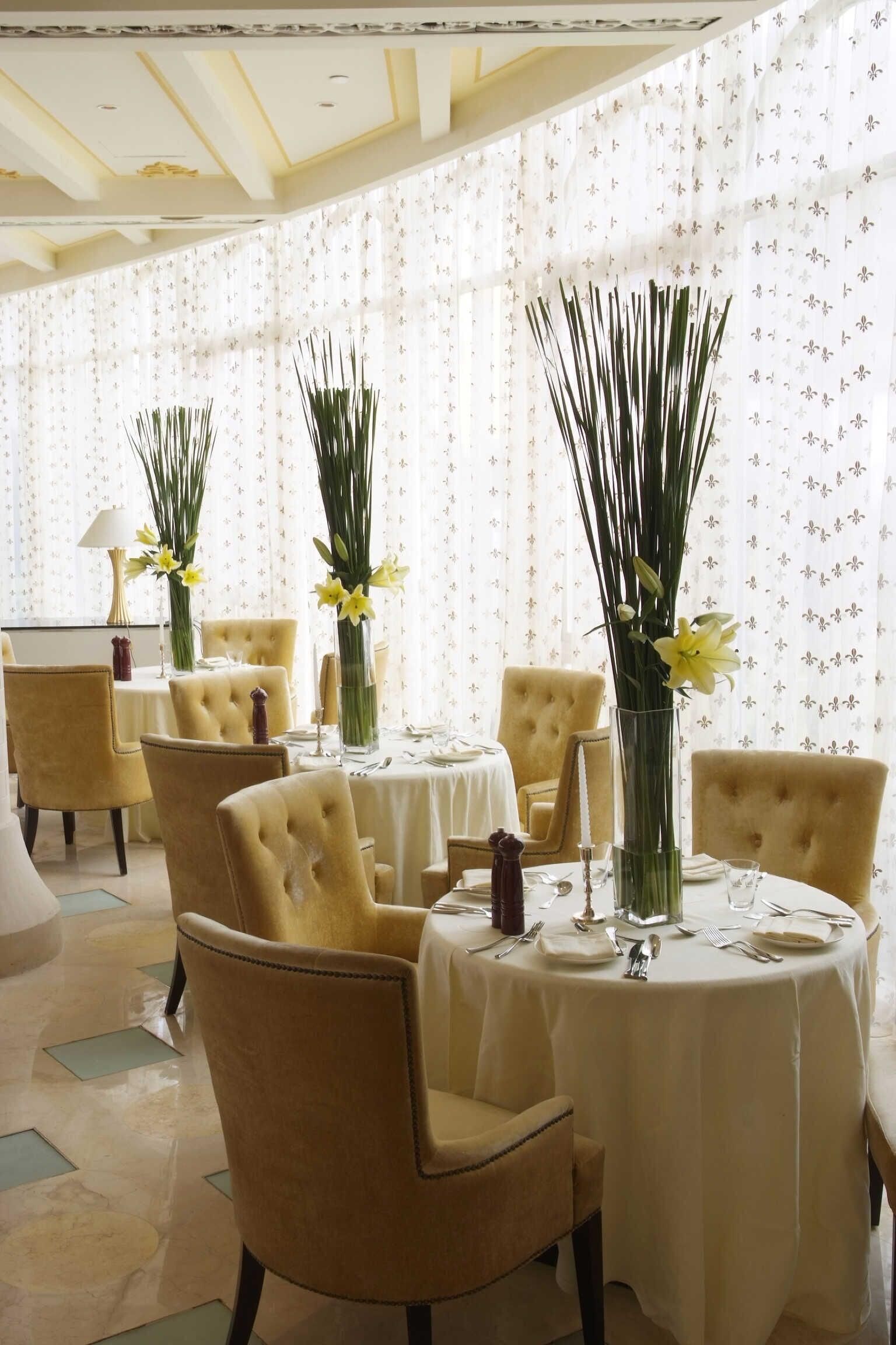 Un restaurante con mesas y sillas y flores en ellas.