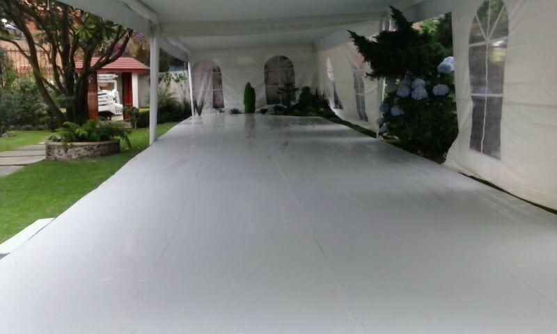 Una gran carpa blanca está colocada sobre un piso de concreto.