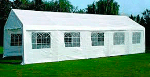 Una gran carpa blanca se encuentra sobre un exuberante campo verde.