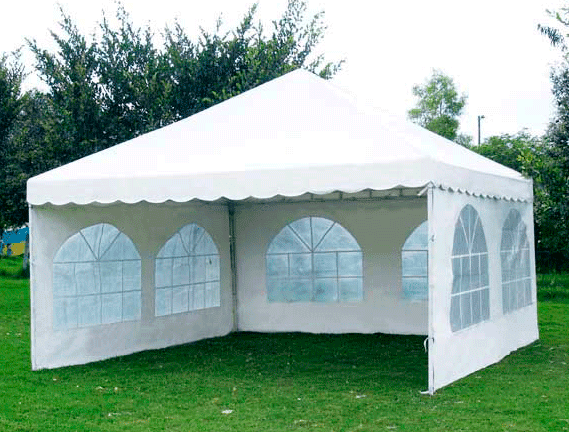 Una tienda de campaña blanca se encuentra sobre un exuberante campo verde.