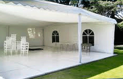 Una carpa blanca con una mesa y sillas dentro.