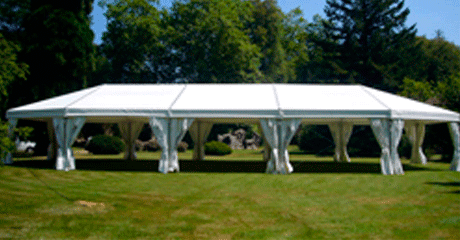 Una gran carpa blanca está situada en el medio de un campo de hierba.