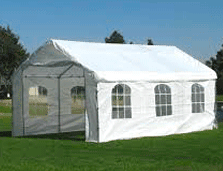 Una tienda de campaña blanca se encuentra sobre un exuberante campo verde.