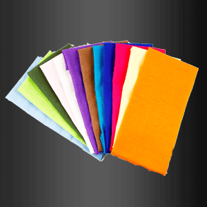Un montón de servilletas de diferentes colores sobre un fondo negro.