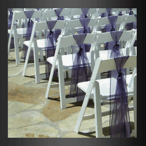 Una fila de sillas plegables blancas decoradas con fajas moradas