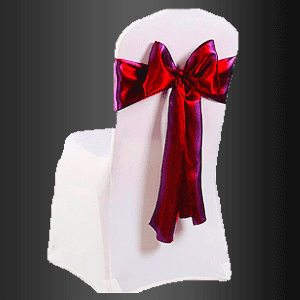 Una silla blanca con un lazo rojo en el respaldo