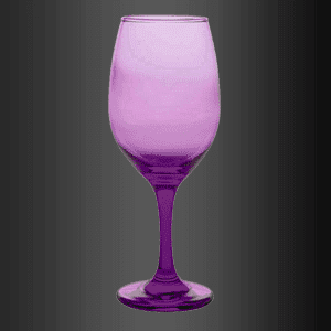 Una copa de vino morado reposa sobre una superficie negra.