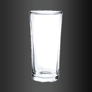 Un vaso transparente reposa sobre una superficie negra.