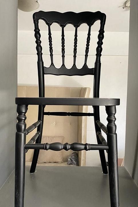 Una silla negra está sentada en un rincón de una habitación.