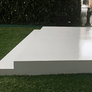 Una plataforma blanca se encuentra encima de un exuberante campo verde.