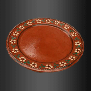 Un plato marrón con flores verdes y blancas encima.