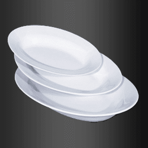 Tres platos blancos se apilan uno encima del otro sobre un fondo negro.