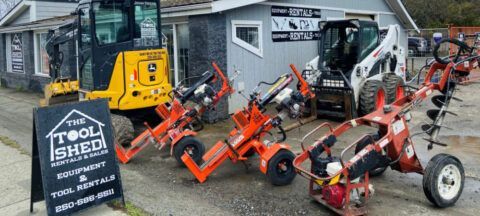 A bunch of tractors are parked in front of a building.