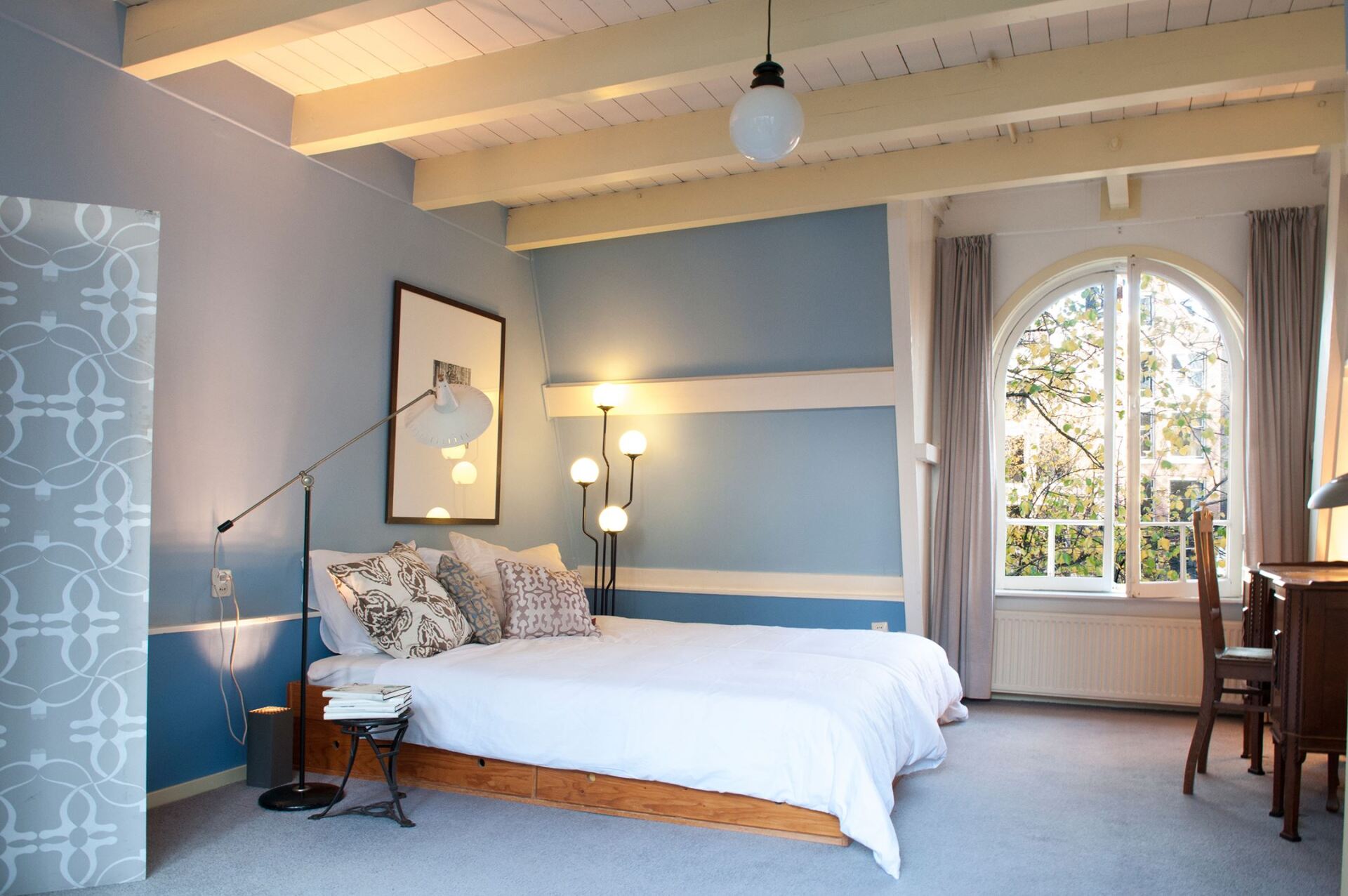 Ein Schlafzimmer mit zwei Betten und einem großen Fenster