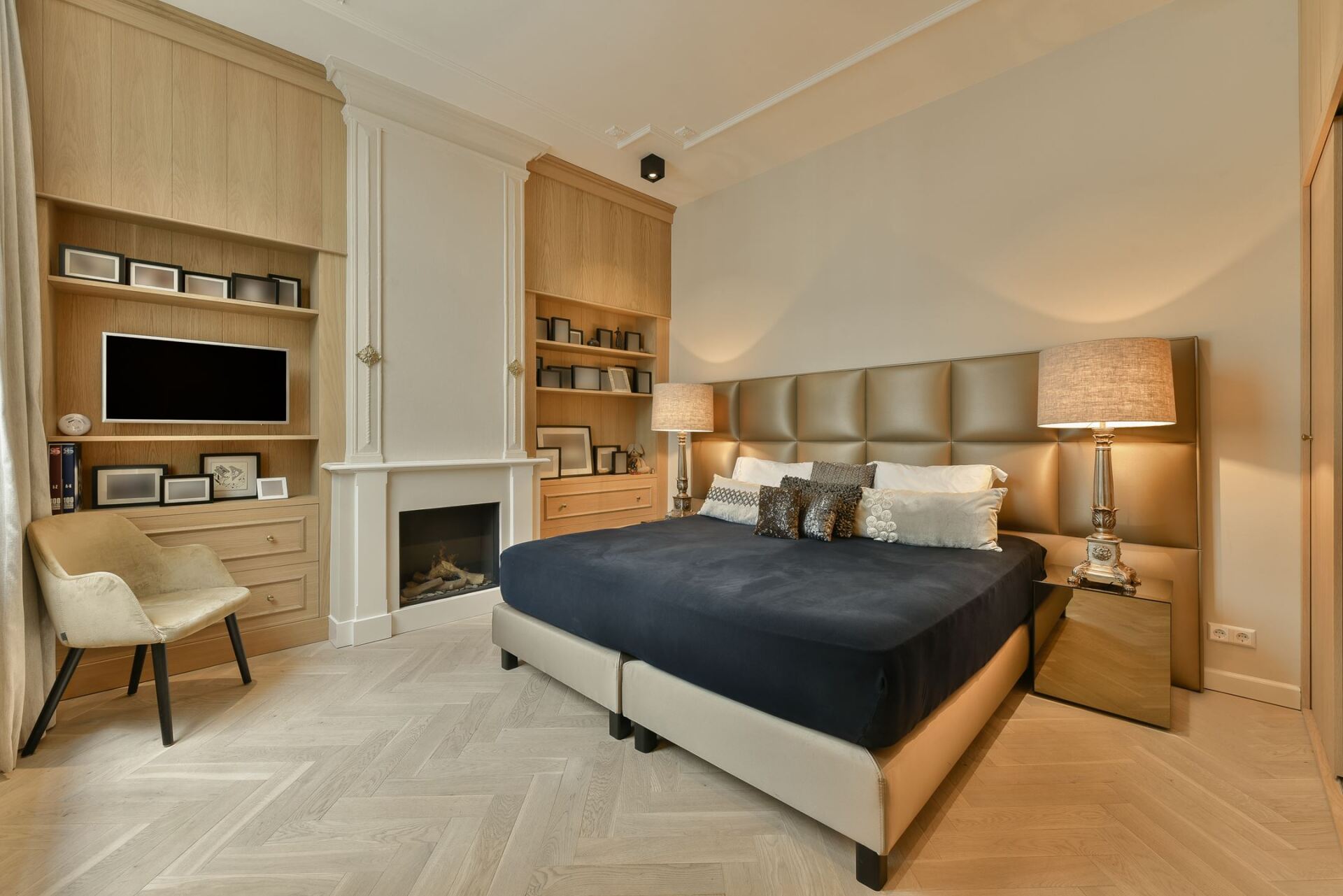 Ein Schlafzimmer mit einem großen Bett und einem Kamin.