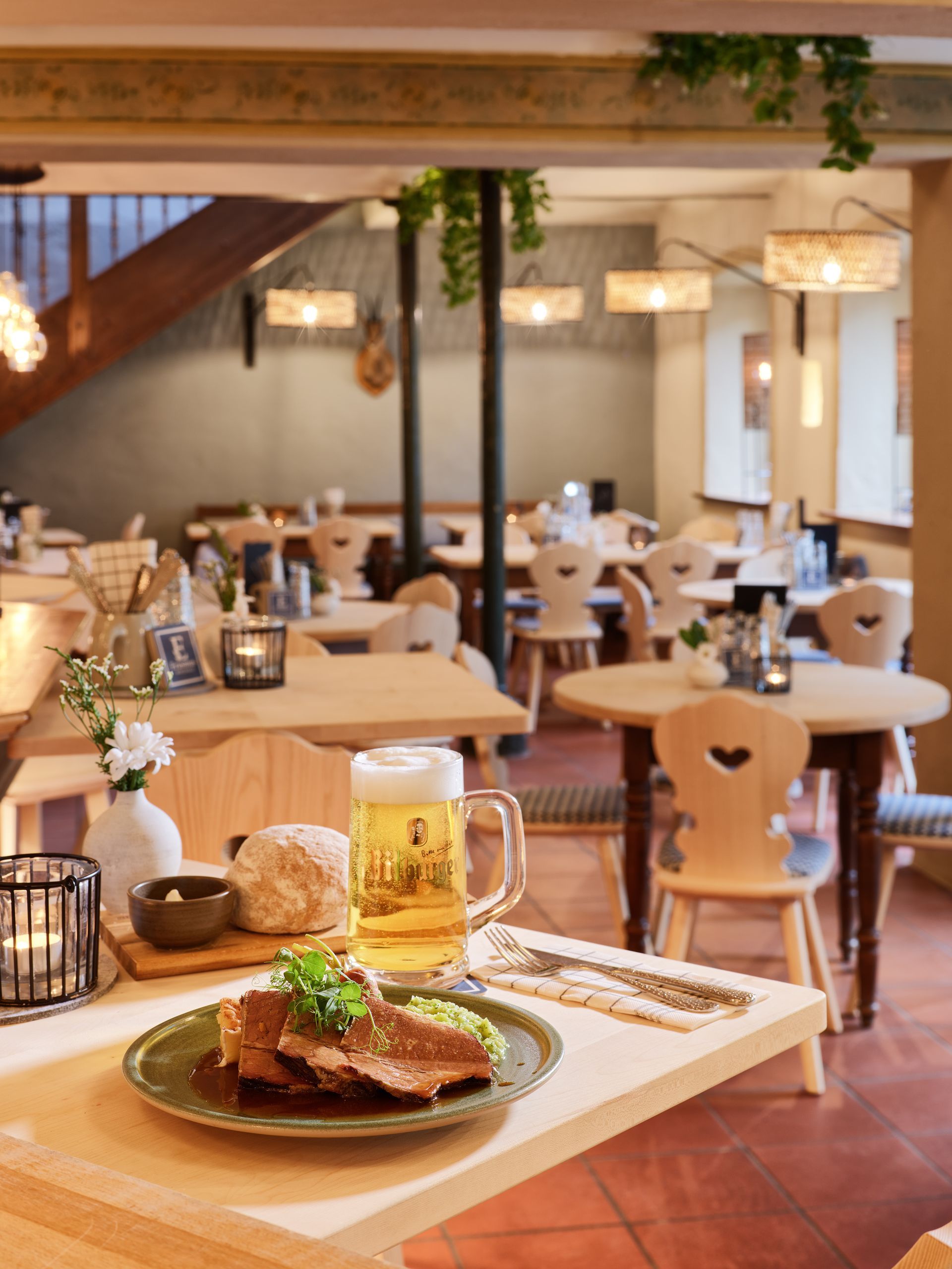 Restaurant-Interieur mit Essen, Bier und Holzmöbeln.