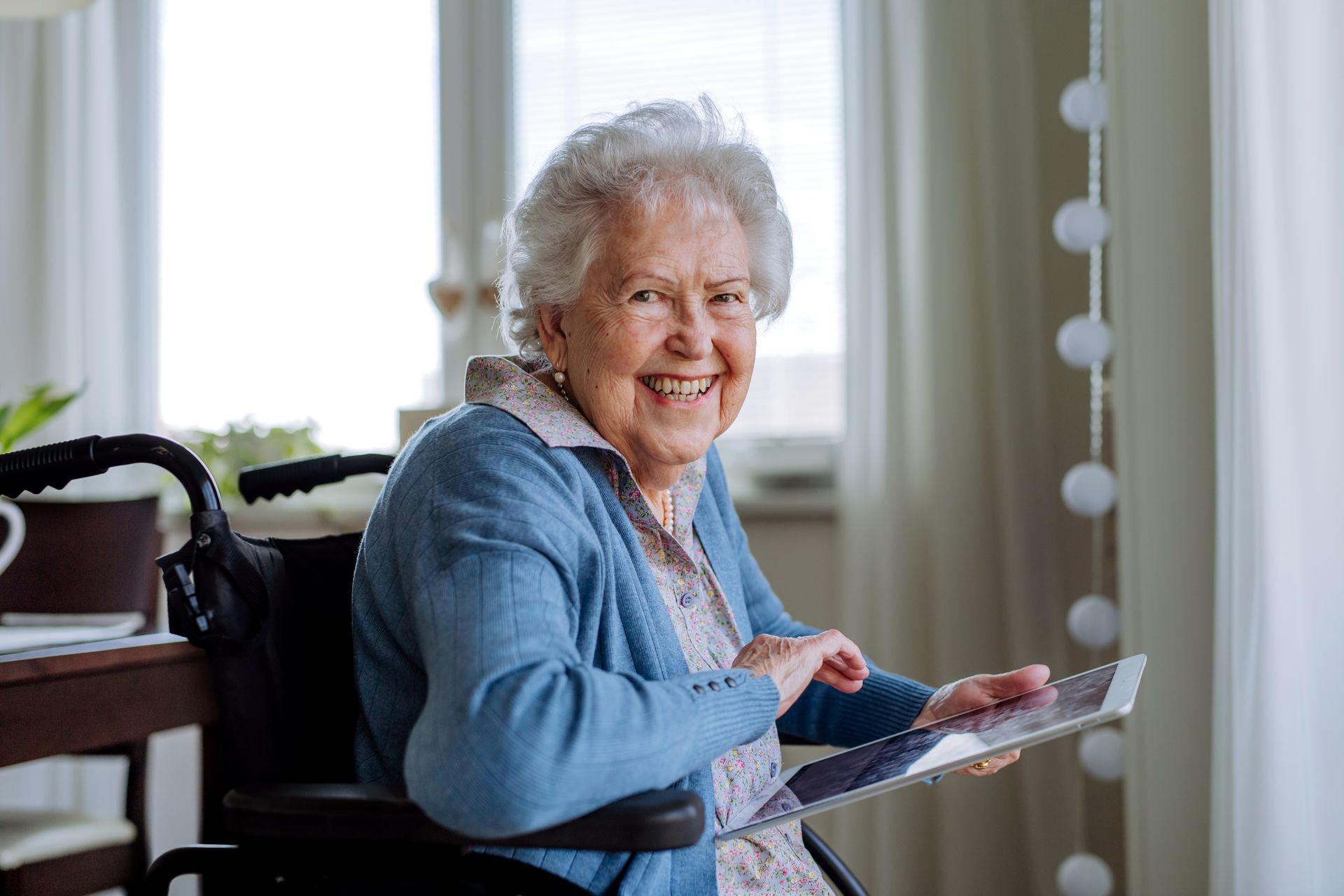 elderly woman in assisted living facility using tablet with bulk internet services
