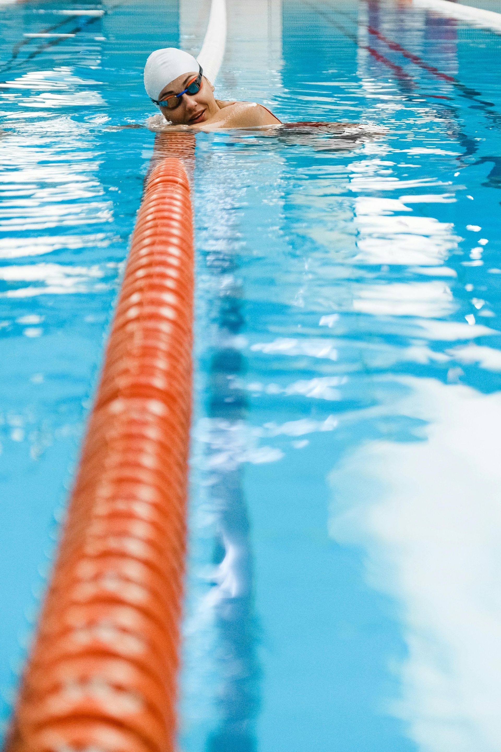 Two-story beige house with a dark gray roof, surrounded by trees.