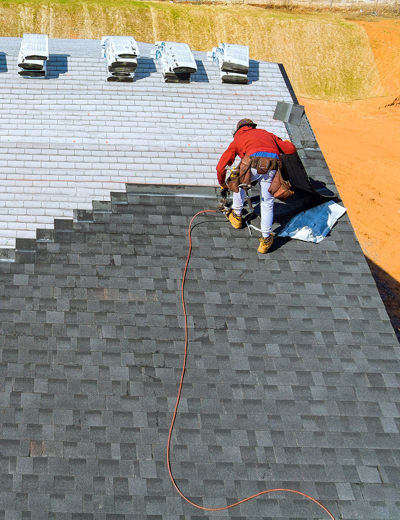 Worker Installing Shingles Roof
