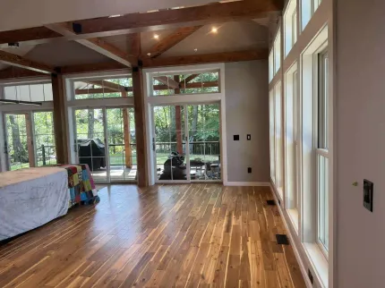 A large room with hardwood floors and lots of windows