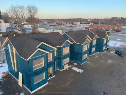 An aerial view of a row of blue houses under construction